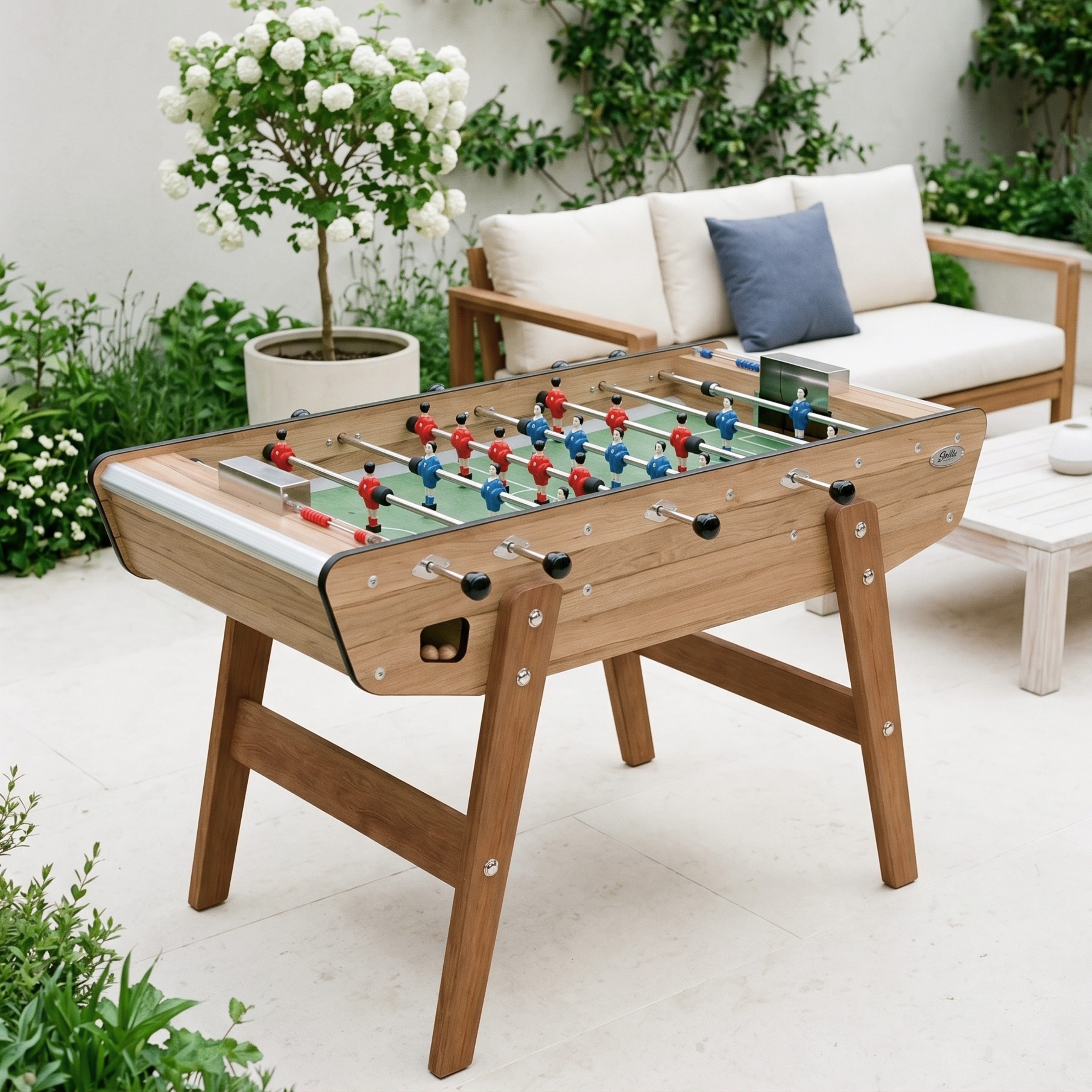 Baby-foot d'extérieur Stella Home Outdoor effet chêne installé sur une terrasse, finition bois élégante et résistante pour un jardin ou espace extérieur chaleureux toute l'année.